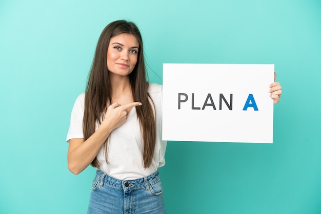 Jeune femme de race blanche isolée tenant une pancarte avec le message PLAN A et le pointant