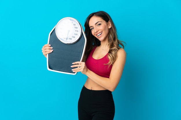 Jeune femme de race blanche avec machine de pesage