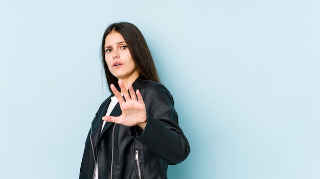 Jeune femme de race blanche sur le mur bleu étant choqué en raison d'un danger imminent