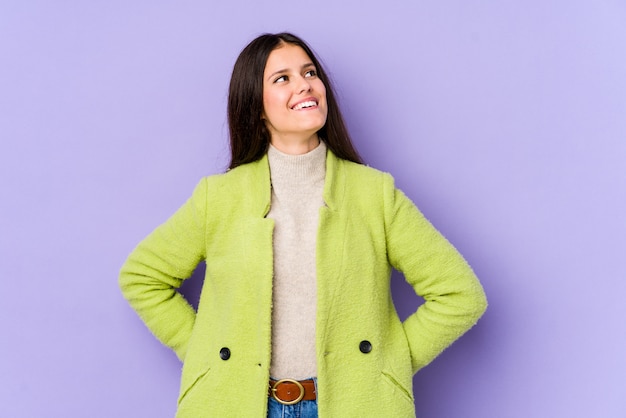 Jeune femme de race blanche sur le mur violet détendu et heureux de rire, le cou tendu montrant les dents.