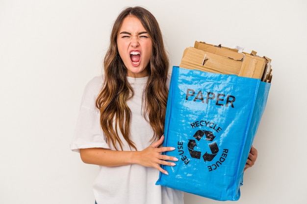 Jeune femme de race blanche recyclage du papier isolé sur fond blanc criant très en colère et agressif.