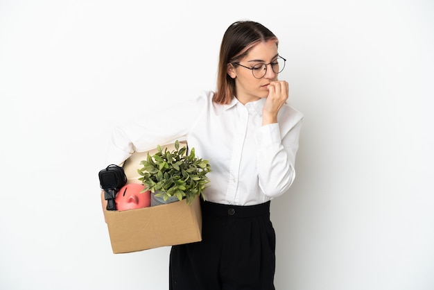 Jeune femme de race blanche se déplaçant dans une nouvelle maison parmi les boîtes isolées sur blanc ayant des doutes