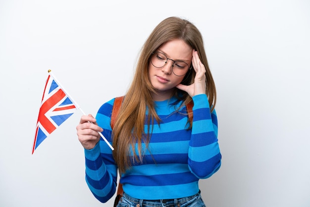 Jeune femme de race blanche tenant un drapeau du Royaume-Uni isolé sur fond blanc avec des maux de tête