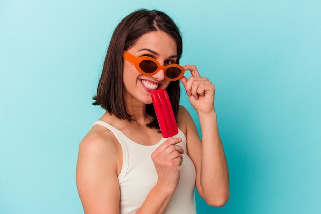 Jeune femme de race blanche tenant une glace isolée sur fond bleu