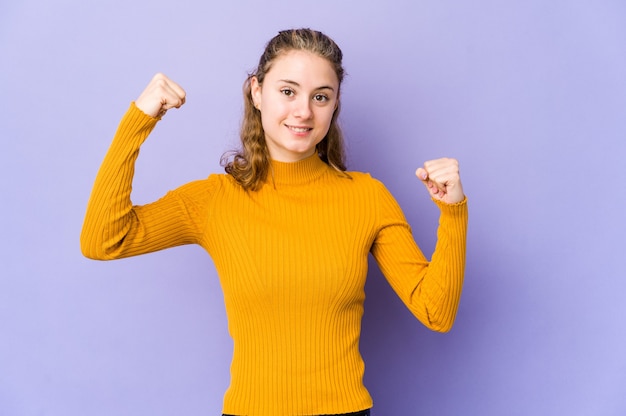 Jeune femme de race blanche sur violet montrant le geste de force avec les bras, symbole du pouvoir féminin