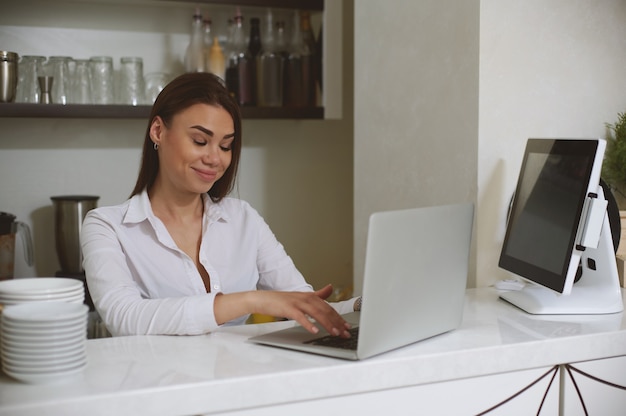 Jeune femme de race blanche avec un visage surpris communique à l'aide d'un ordinateur portable