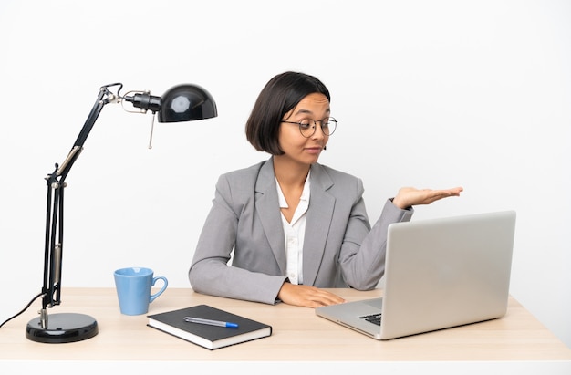 Jeune femme de race mixte travaillant au bureau tenant un espace avec des doutes