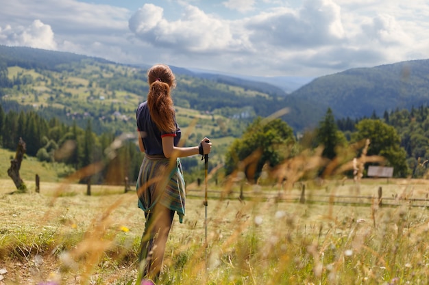 Jeune femme randonneur debout admirant une vue sur la montagne donnant sur les lointaines chaînes de montagnes et de vallées