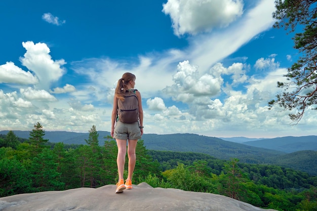 Une jeune femme randonneuse debout seule sur un sentier de montagne appréciant la vue de la nature d'été sur un chemin sauvage Concept de mode de vie actif