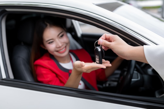 Jeune femme recevant les clefs de sa nouvelle voiture,