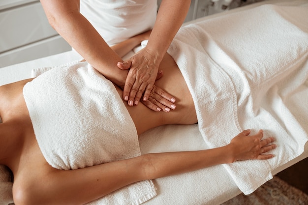 Jeune femme recevant un massage abdominal dans un salon spa