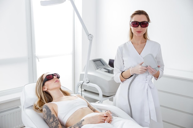 Jeune femme recevant un traitement au laser dans un salon de beauté