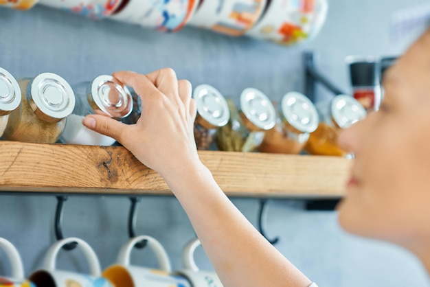 Jeune femme à la recherche d'épices dans la cuisine