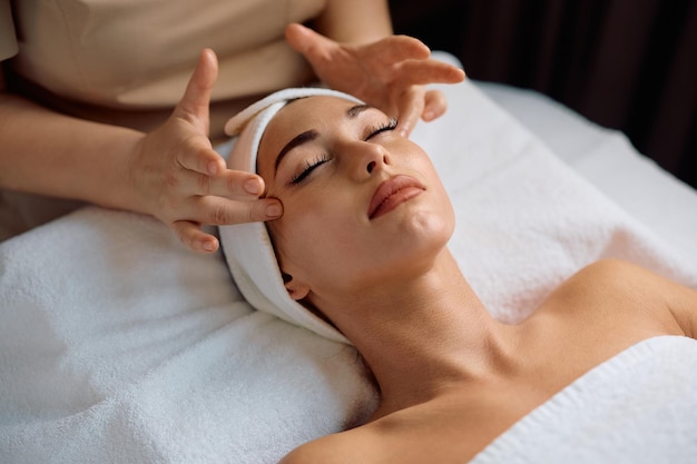 Une jeune femme reçoit un massage du visage dans un salon de beauté.