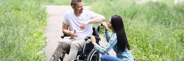 Photo jeune femme réconfortant son mari en fauteuil roulant en convalescence