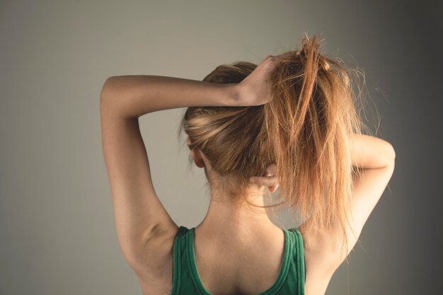 La jeune femme redresse ses cheveux avec ses mains