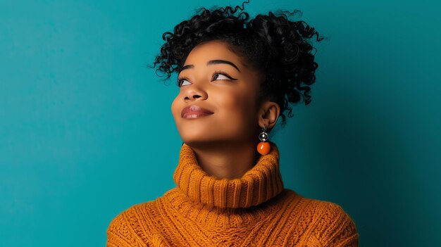 Une jeune femme réfléchie portant un pull à col rouget brun lève la tête avec un léger sourire sur son visage sur un fond bleu