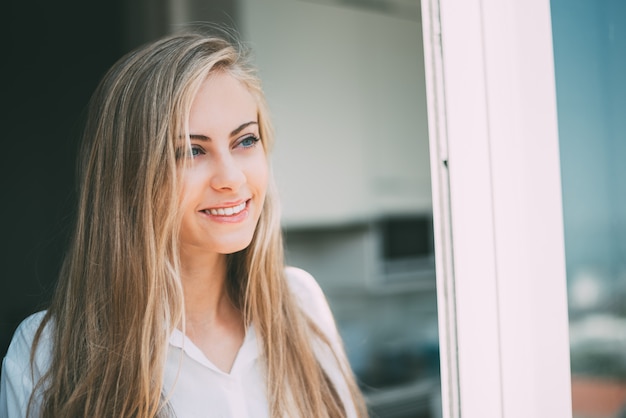 Jeune femme réfléchie, regardant par la fenêtre