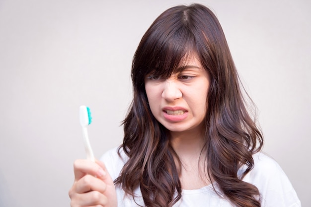 jeune femme refuse de se brosser les dents. concept pour les soins de santé