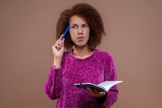 Jeune femme avec un regard pensif prenant des notes