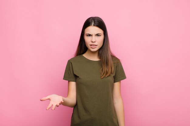 Jeune femme regardant en colère, agacé et frustré crier wtf