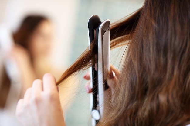 Jeune femme regardant dans le miroir de la salle de bain