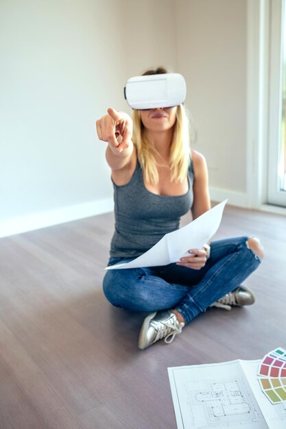 Jeune femme regardant la décoration de sa maison avec des lunettes de réalité virtuelle Mise au point sélective sur la main au premier plan