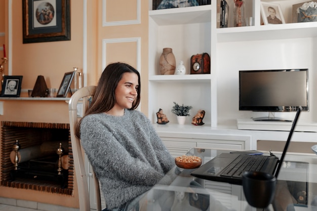 Jeune femme regardant une émission sur son ordinateur portable