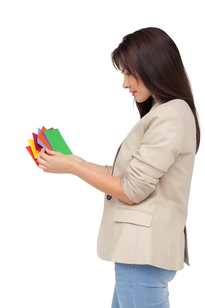 Jeune femme regardant des papiers colorés