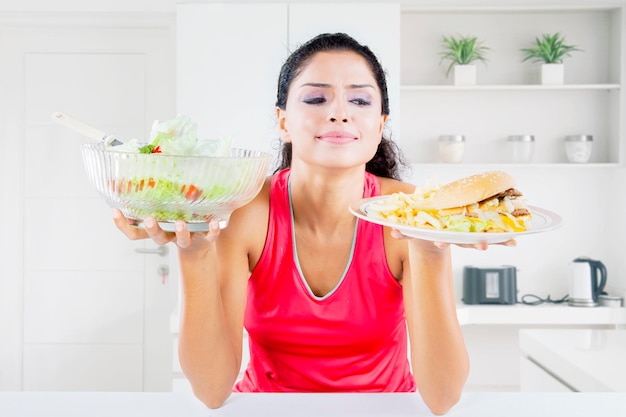 Jeune femme regardant la restauration rapide dans la cuisine