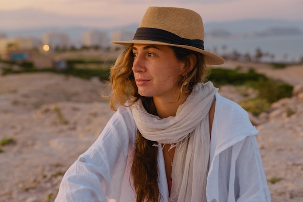 Photo jeune femme regarde le coucher du soleil pendant ses vacances