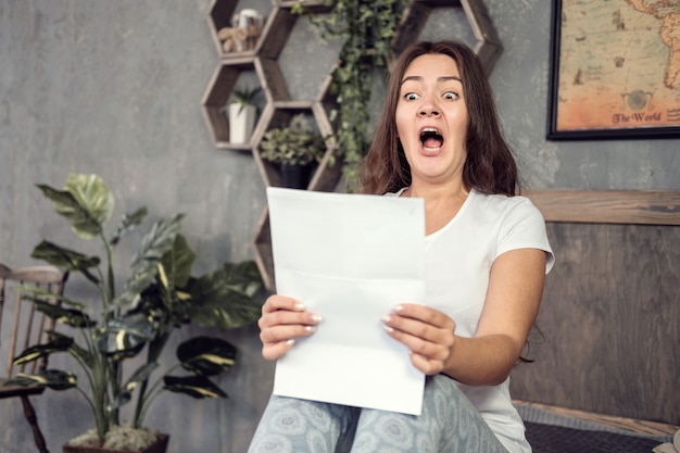 jeune femme regarde les documents avec surprise