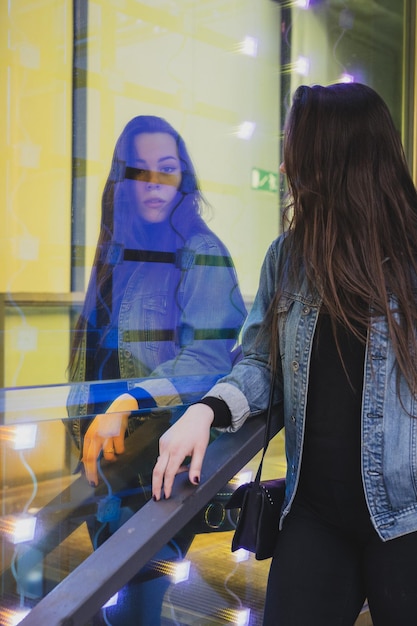 Photo une jeune femme regarde un magasin éclairé.