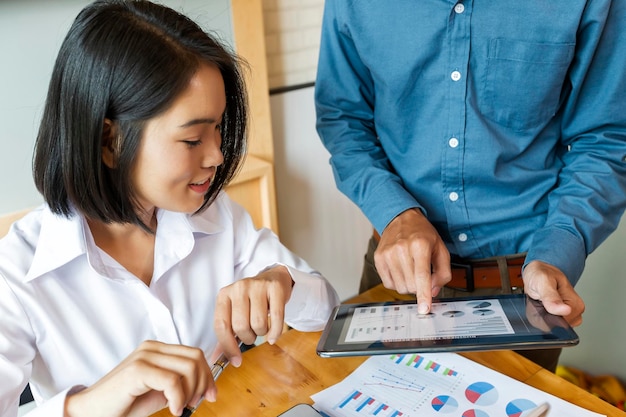 Une jeune femme regarde un smartphone sur la table.