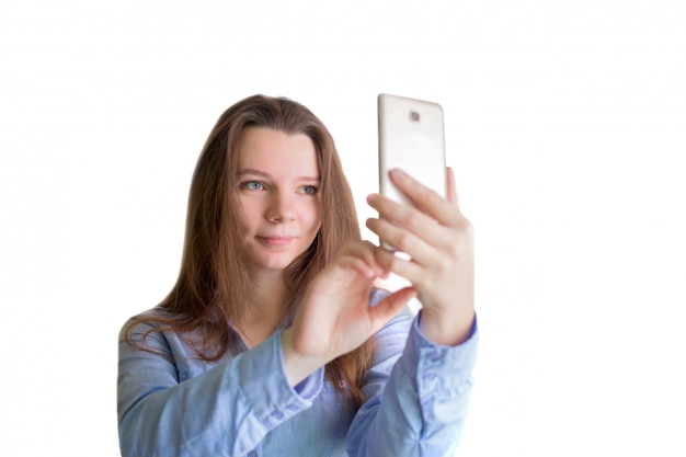 jeune femme regarde le téléphone sur fond blanc.