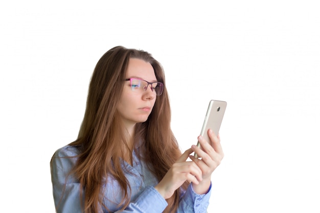 jeune femme regarde le téléphone sur fond blanc.