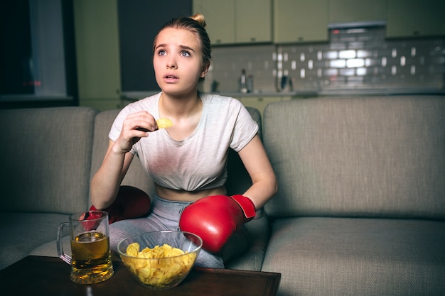 Jeune femme regarder la boxe à la télévision la nuit