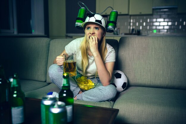 Jeune femme regarder un match de football à la télévision la nuit