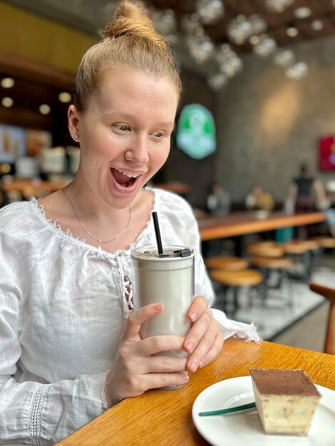 Photo une jeune femme à régime souffrant d'un trouble de l'alimentation dans un café tenant un morceau de gâteau refusant le sucre