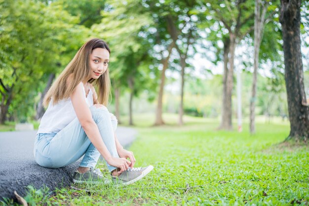 Jeune femme relaxante dans le parc naturel. Vacances d'été dans le jardin.