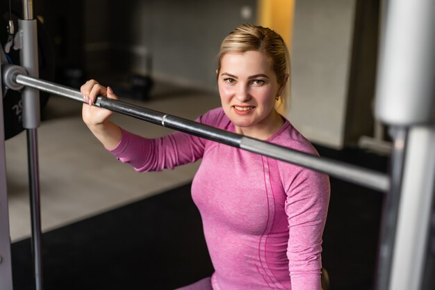 jeune femme de remise en forme exécuter un exercice avec une machine d'exercice en salle de sport, photo horizontale