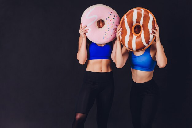 Jeune femme de remise en forme avec des mains gantées avec des muscles abdominaux tendus