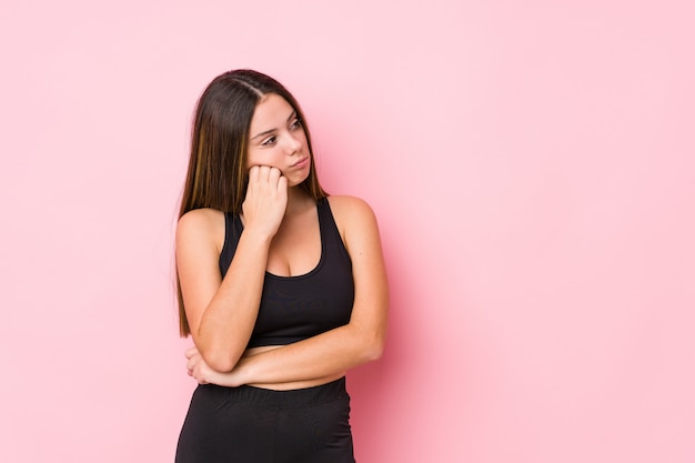 Jeune femme de remise en forme qui se sent triste et songeuse, regardant l'espace copie.