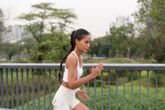 Une jeune femme de remise en forme en vêtements de sport faisant de l'exercice dans le parc de la ville