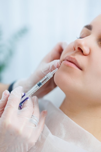 Une jeune femme à un rendez-vous avec une esthéticienne des injections de beauté pour le visage Procédure de traitement chez un dermatologue