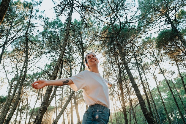 Jeune femme respirant de l'air pur dans la forêt naturelle Concept de mode de vie sain de bien-être en plein air frais concept d'arbres pour l'environnement réchauffement climatique personnes de mode de vie sain dans la nature aucune pollution