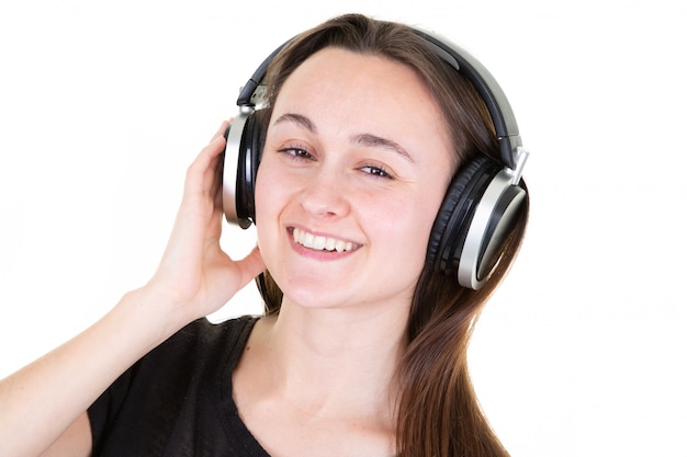 Jeune femme riant et écoutant de la musique avec des écouteurs de téléphone