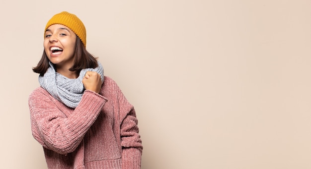 Jeune femme riant joyeusement les bras croisés, avec une pose détendue, positive et satisfaite