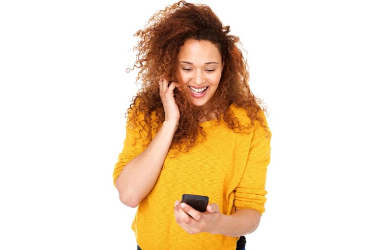 Photo une jeune femme riant avec un téléphone intelligent sur un fond blanc isolé