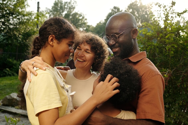 Photo jeune femme riante regardant sa fille parmi les membres de la famille